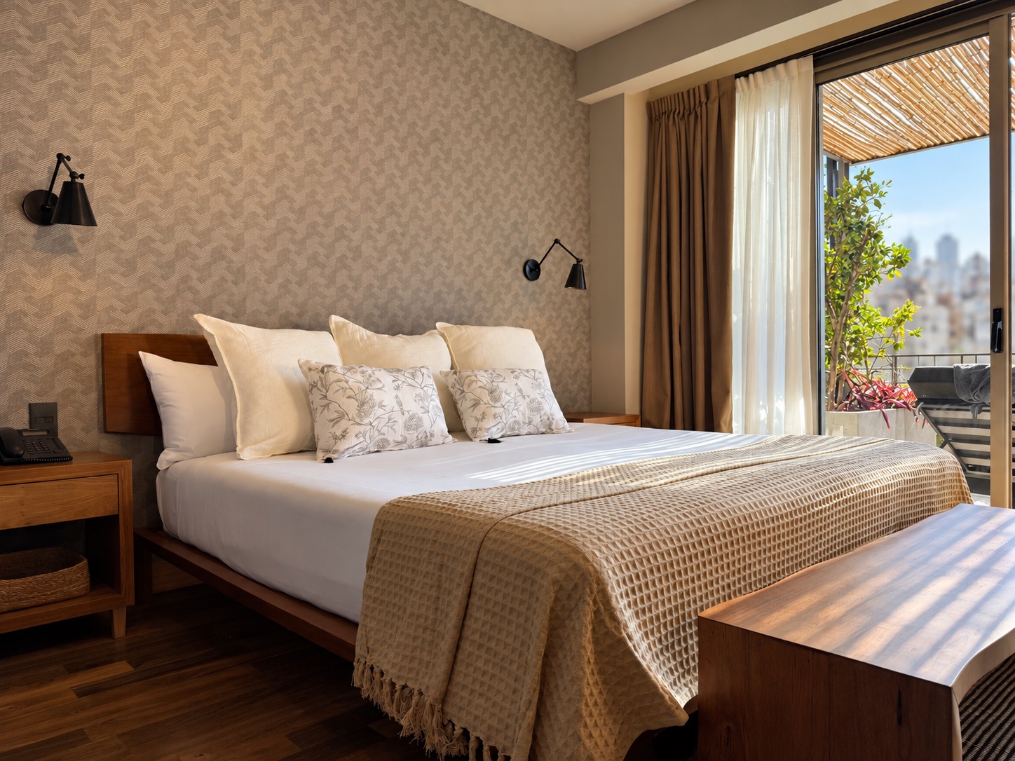 Cama king en el dormitorio de la Suite Terrace con la terraza y vista a la ciudad