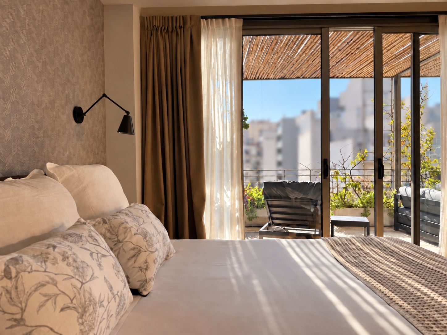 Cama de la Suite Terrace con las puertas corredizas abiertas a la terraza privada