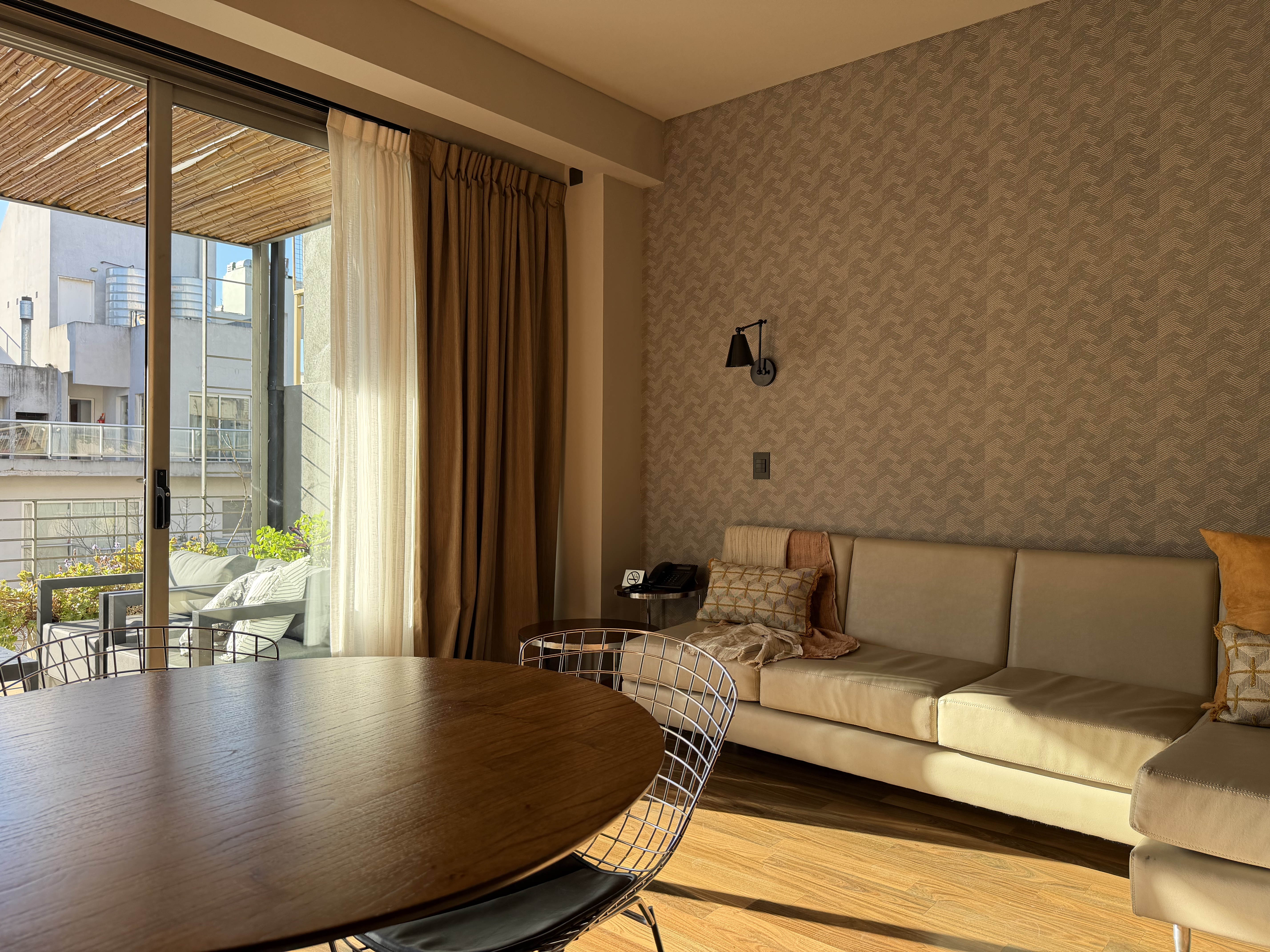 Living de la Suite Terrace con sillón, mesa comedor y salida a la terraza