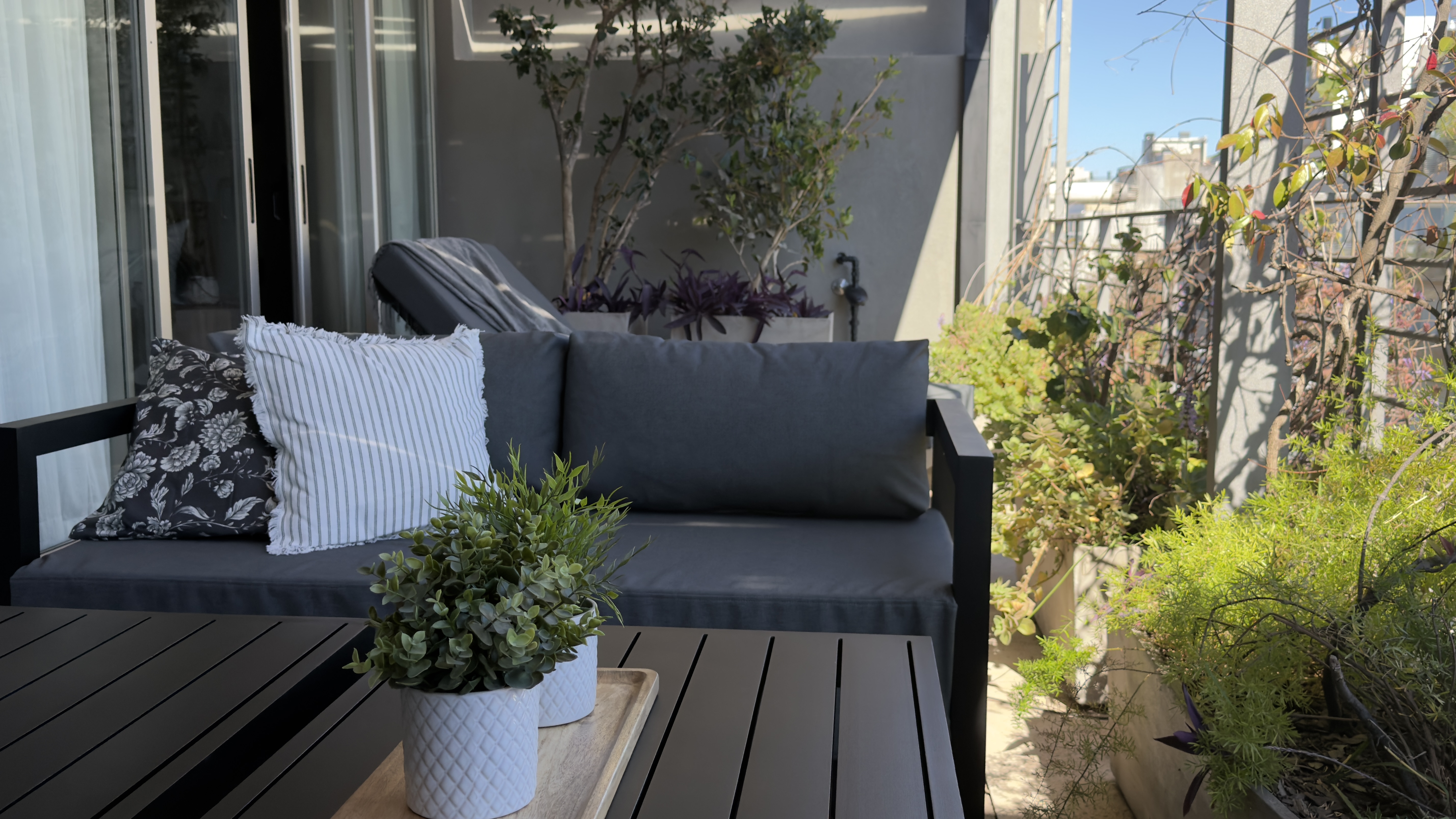 Sillón y mesa baja en la terraza de la Suite Terrace, rodeados de plantas