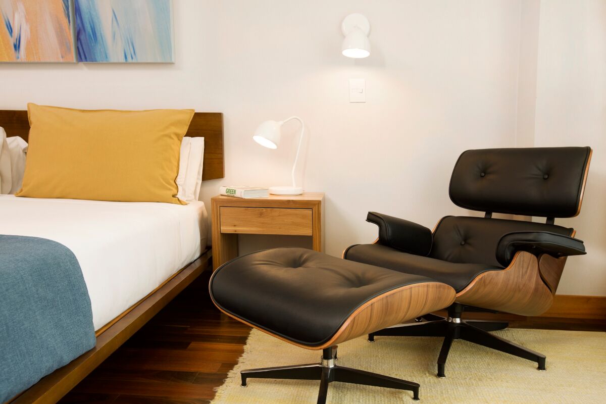 Detalle una butaca de diseño Eames en una habitación Deluxe